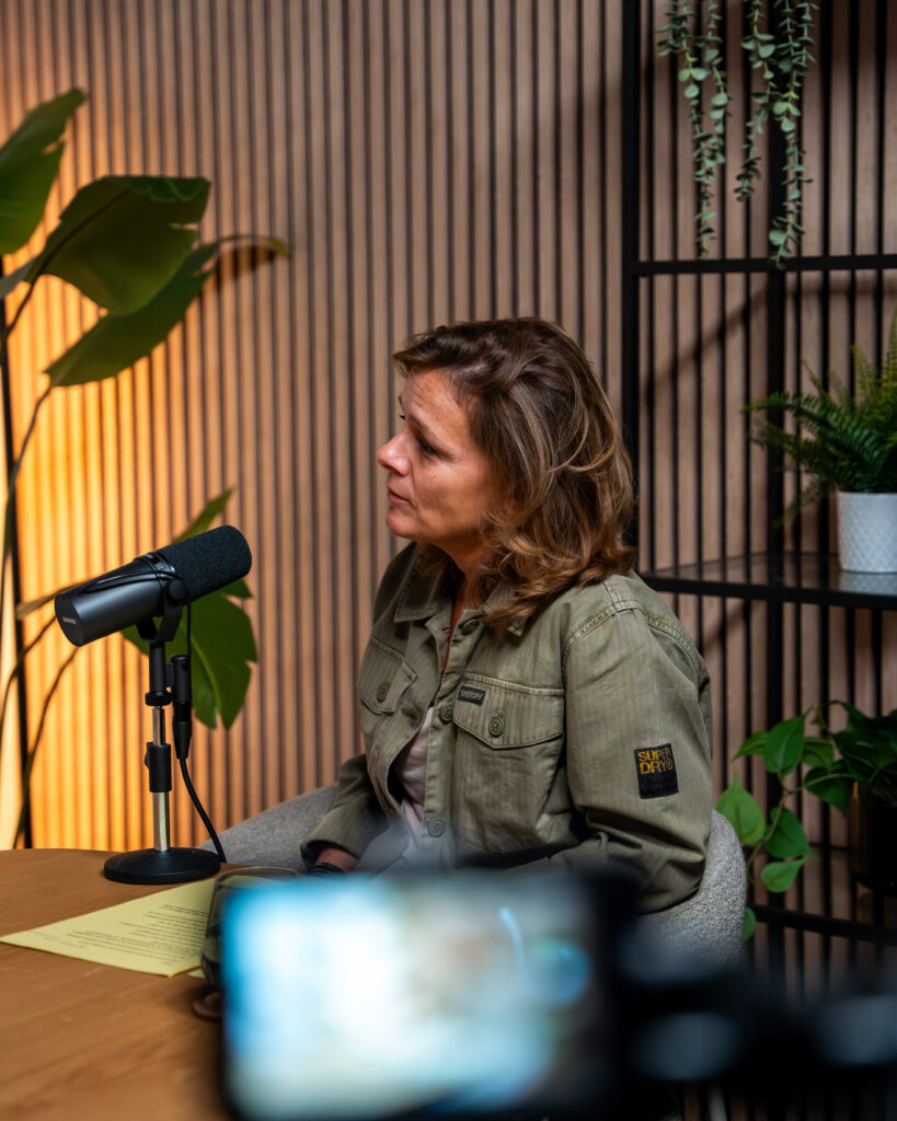 Marjolein achter een microfoon tijdens een opname van de podcast Coffee & Qi.
